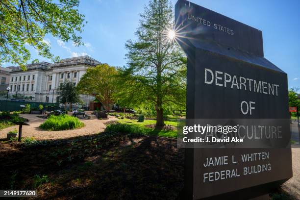 The sun flares behind the sign marking the headquarters building for the US Department of Agriculture on April 18 in Washington, DC.