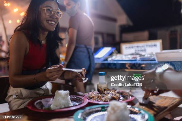 un couple de lesbiennes aime manger de la nourriture locale à l’extérieur - stand de restauration rapide photos et images de collection