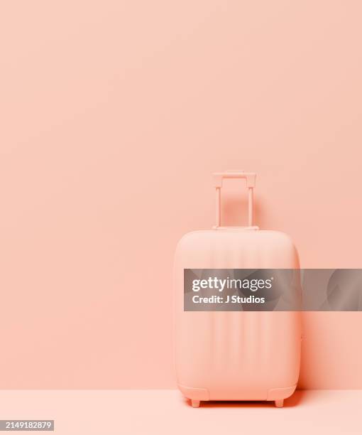 suitcase against wall - peach color stock pictures, royalty-free photos & images