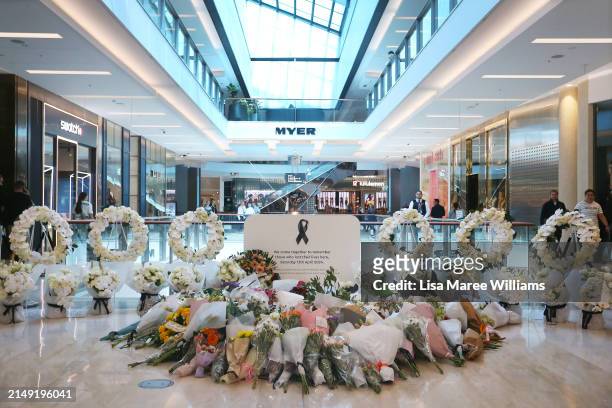 Floral tributes are seen at a memorial site during the re-opening of the Westfield Bondi Junction shopping centre on April 19, 2024 in Sydney,...