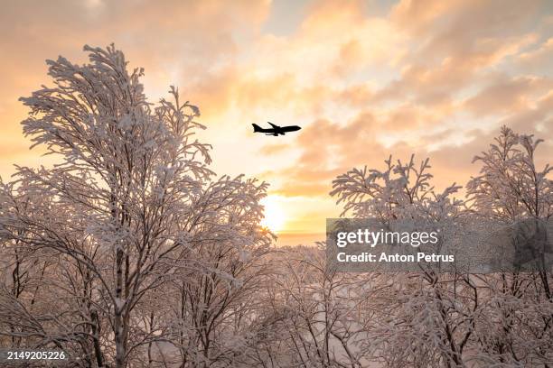 airplane in the sunset sky under a winter landscape - clouds from aircraft point of view stock pictures, royalty-free photos & images