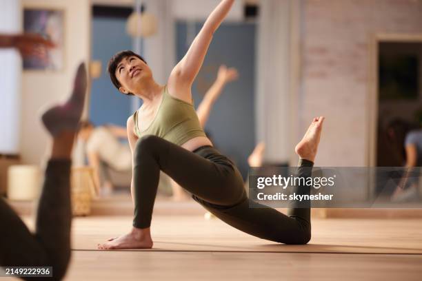 happy japanese woman stretching in yoga studio. - pilates bildbanksfoton och bilder