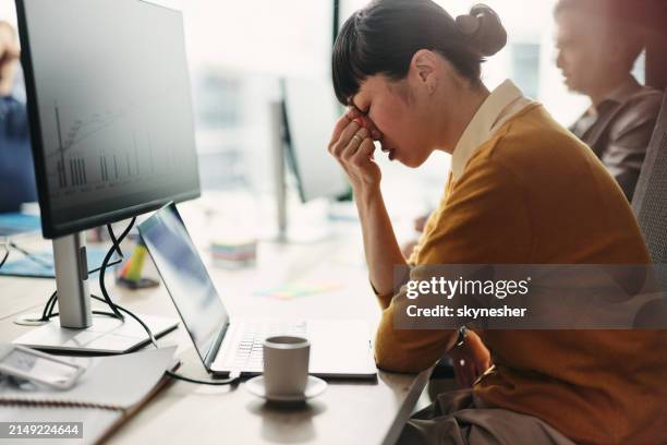 diseñador web japonés que tiene dolor de cabeza mientras trabaja en pc en la oficina. - presión fotografías e imágenes de stock