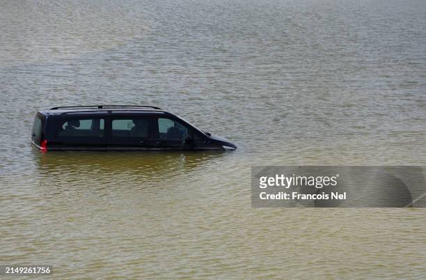 An abandoned vehicle lies in floodwater on April 19, 2024 in Dubai, United Arab Emirates. Atypically heavy rains in the UAE on Monday and Tuesday...