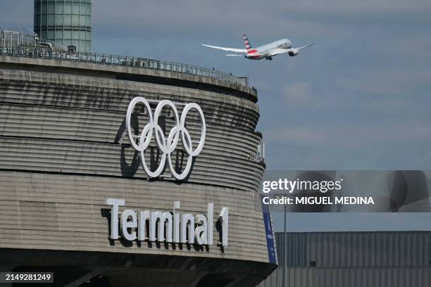 This photograph taken in Roissy-en-France on April 23 shows the Olympic rings on the Roissy - Charles de Gaulle Airport terminal 1, as an aircraft...