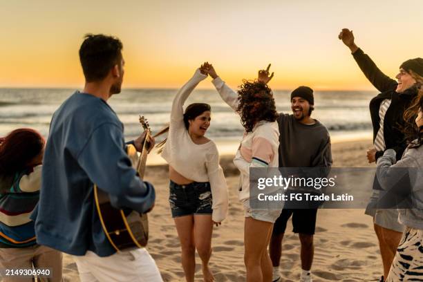 freunde, tanzen und spaß am strand - strandparty stock-fotos und bilder