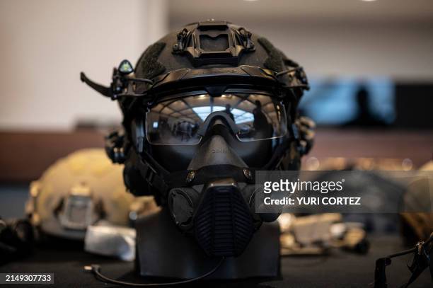 An exhibitor shows a safety helmet with a communication system, eye protection glasses, and implements to add a night vision system during the...