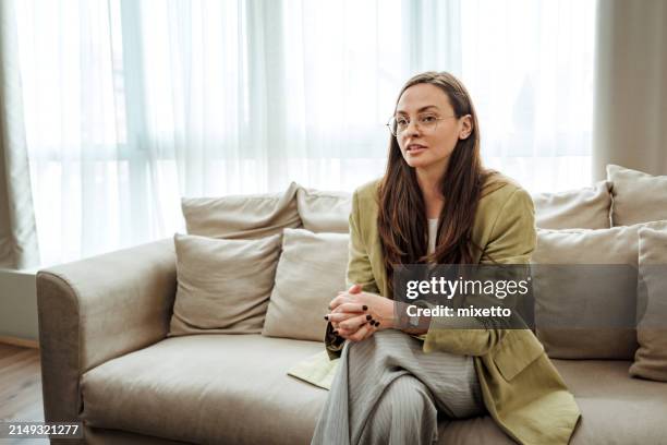 giovane bella donna d'affari ben vestita che ha colloquio di lavoro, seduta su un divano all'ufficio moderno - primo lavoro foto e immagini stock