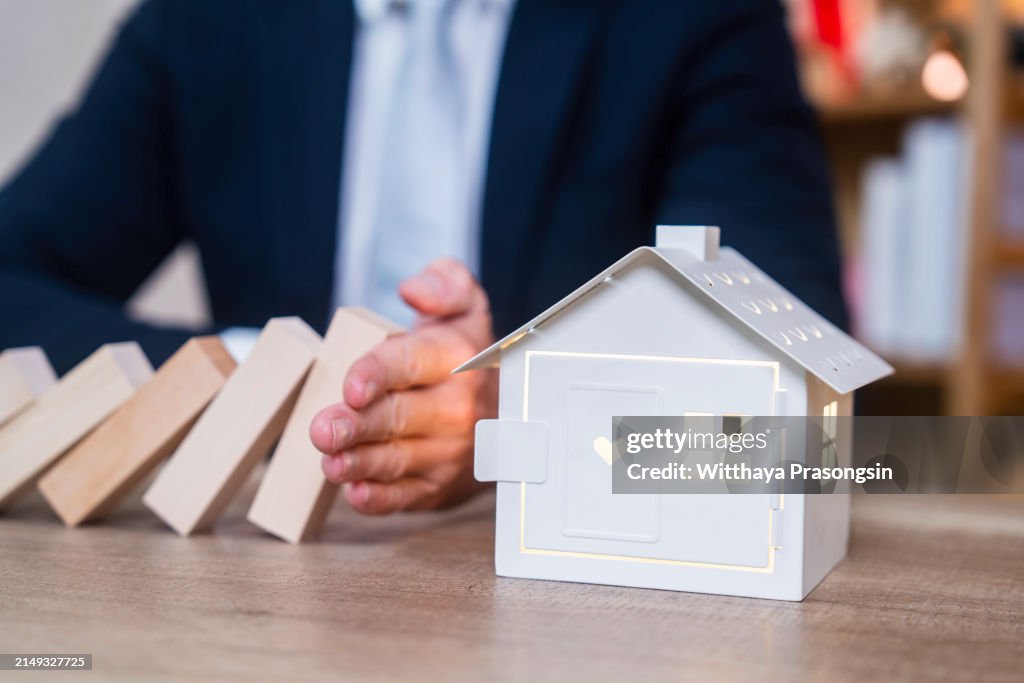 Businessman Hand Stopping The Wooden Blocks From Falling