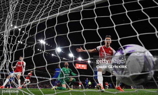 Arsenal's Belgian midfielder Leandro Trossard reacts as Arsenal's English defender Ben White celebrates after as his cross-shot hits the back of the...