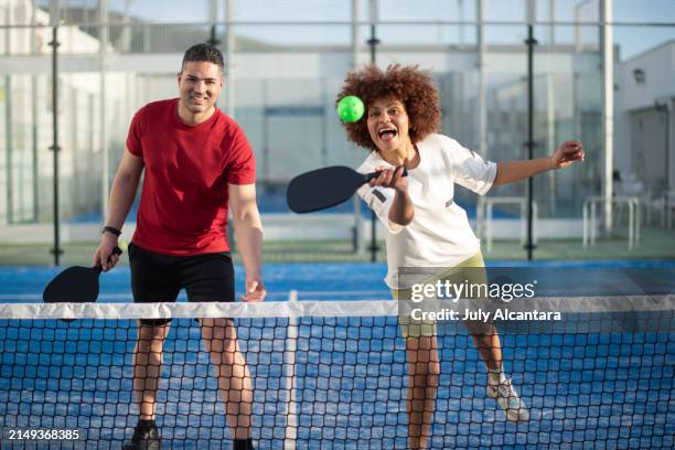couple playing pickleball in court - woman shooting man stock pictures, royalty-free photos & images