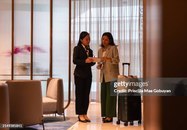the concierge warmly welcomes a business traveler - singapore airport stock pictures, royalty-free photos & images