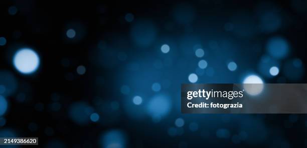 blue defocused lights over dark background - defocussed stock pictures, royalty-free photos & images