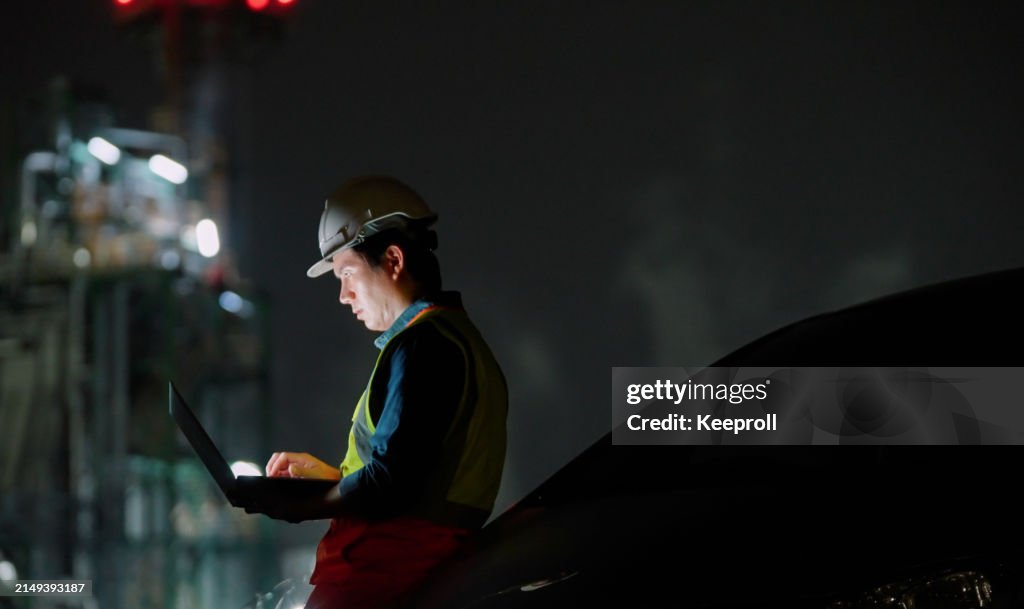 Asian engineer working on laptop at night