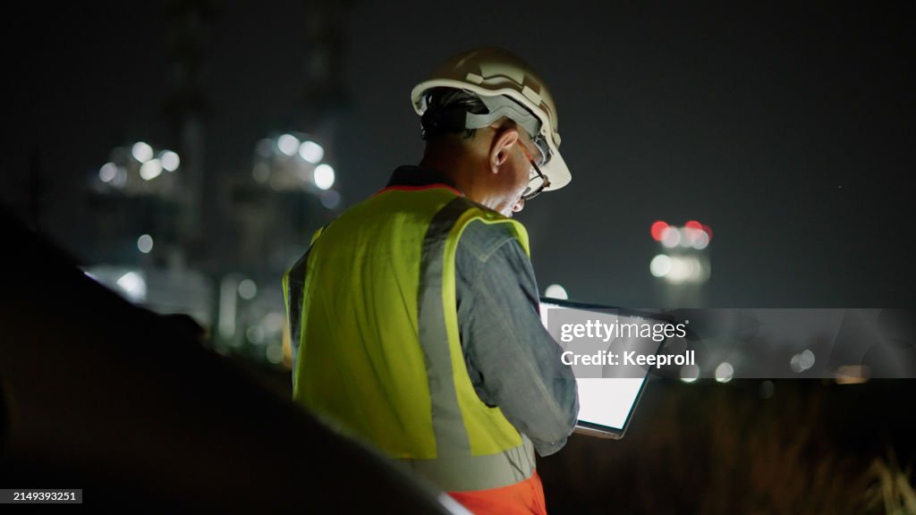 Asian engineer working on laptop at night