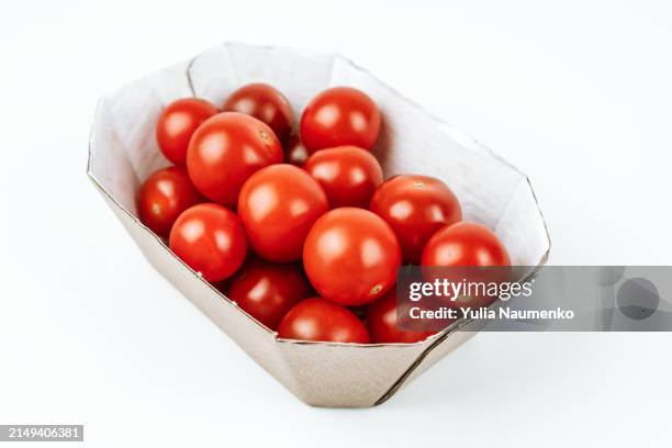 cherry tomatoes in a cardboard box on a white background. - tomate cerise photos et images de collection