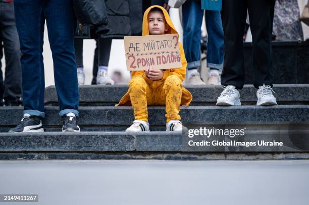 Little boy with a banner that reads 'Where is my dad? Two years of captivity' attends the rally organized by Ukrainian POWs relatives near the...