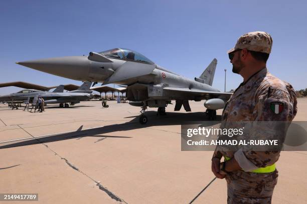 An aviation technician from the Italian army stand near an Italian air force Eurofighter Typhoon fighter aircraft at Balad Air Base north of Baghdad...