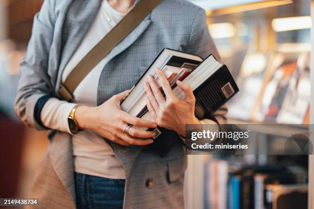 close up photo of women hands holding few books in the bookshop - small group of objects stock pictures, royalty-free photos & images