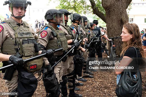 Student quietly stares at a row of Texas State Troopers as pro-Palestinian students protest the Israel-Hamas war on the campus of the University of...