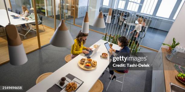 donne d'affari che lavorano nella caffetteria dell'ufficio - pausa pranzo foto e immagini stock