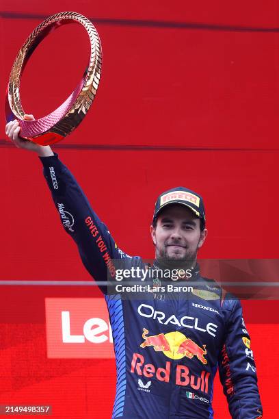 Third placed Sergio Perez of Mexico and Oracle Red Bull Racing celebrates with trophy on the podium during the F1 Grand Prix of China at Shanghai...