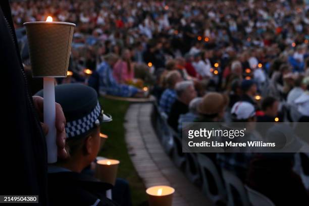 Police and members of the public attend a community candlelight vigil for the victims of the Bondi Junction tragedy at Dolphin Court at Bondi Beach...