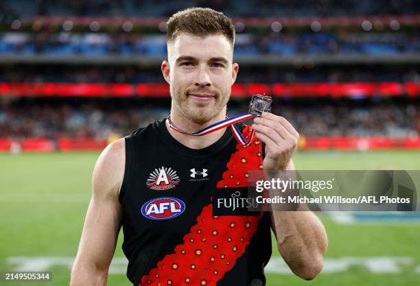 Zach Merrett of the Bombers poses with the Anzac Medal during the 2024 AFL Round 07 match between the Essendon Bombers and the Collingwood Magpies at...