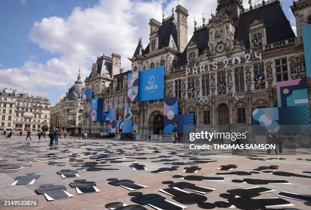 This photograph taken on April 25 shows a view of Paris' town hall, with displayed cardboard silhouettes placed by French labour union CGT members in...