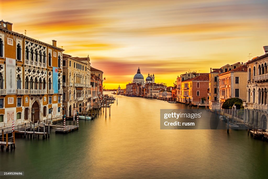 Sunrise colors of Grand Canal and Basilica di Santa Maria della Salute, very long exposure view from Accademia bridge, Venice, Italy