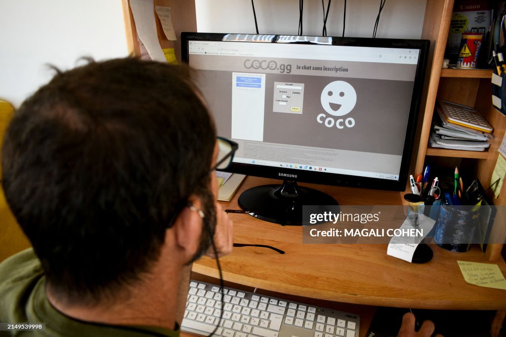 A man logs on to the Coco website on his computer in Les Sables d ...