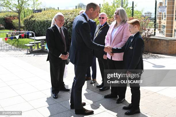 Britain's Prince William, Prince of Wales speaks with twelve-year-old Freddie Hadley , who made the initial invitation to visit the school, during a...