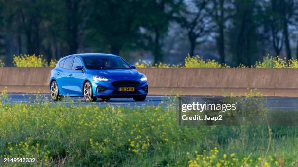 dutch blue 2019 ford focus driving on the a35 highway - dichterbij komen stockfoto's en -beelden