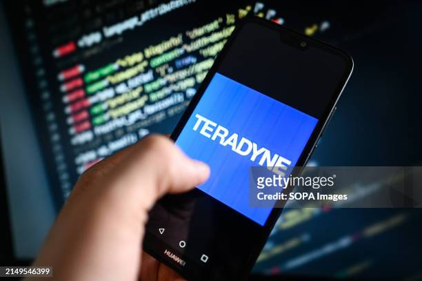 In this photo illustration a Teradyne logo is displayed on a smartphone with coding on the background.