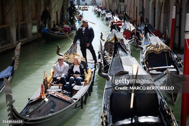 Gondolier sails with two customers near San Marco Square in Venice, on April 25, 2024. The new strategy to lower the number of tourists visiting the...