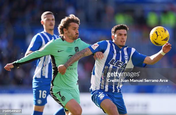 Javi Lopez of Deportivo Alaves is challenged by Antoine Griezmann of Atletico Madrid during the LaLiga EA Sports match between Deportivo Alaves and...