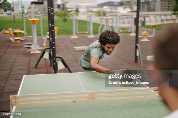 young man playing table tennis outdoors - tennis street stock pictures, royalty-free photos & images