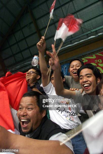 Indonesian fans cheer as Indonesia's Taufik Hidayat defeats Malaysia's Ong Ewe Hock during their men's singles round of 16 badminton match at the...