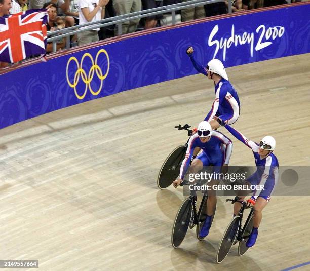 Three members of the British pursuit team celebrate after breaking the Olympic record during the men's team pursuit qualifyings with a time of...