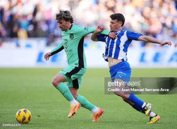 Antoine Griezmann of Atletico Madrid is challenged by Antonio Blanco of Deportivo Alaves during the LaLiga EA Sports match between Deportivo Alaves...
