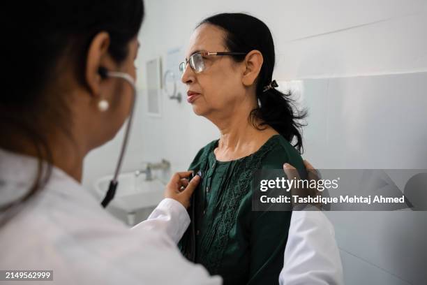 indian doctor examining a asian patient. - assam people stock pictures, royalty-free photos & images