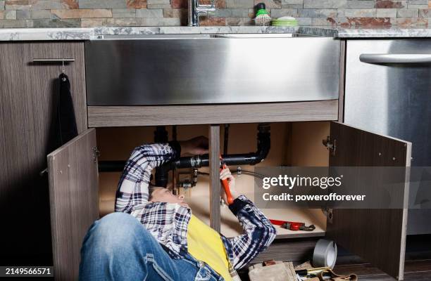 woman plumber fixing a kitchen sink - onder stockfoto's en -beelden