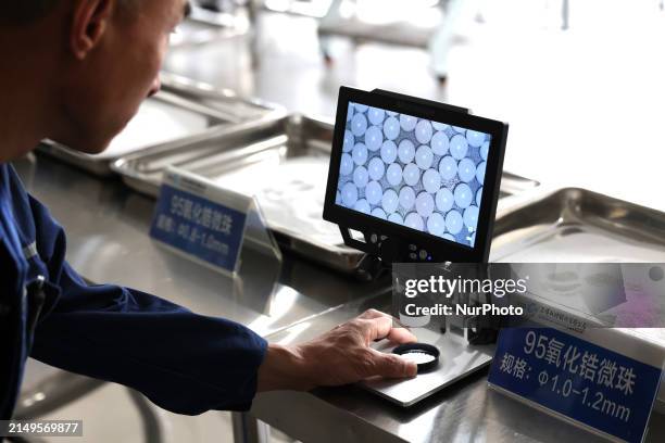 Staff member is looking at zirconia microbeads in a production workshop of a new material enterprise in Ningde, China, on April 25, 2024.