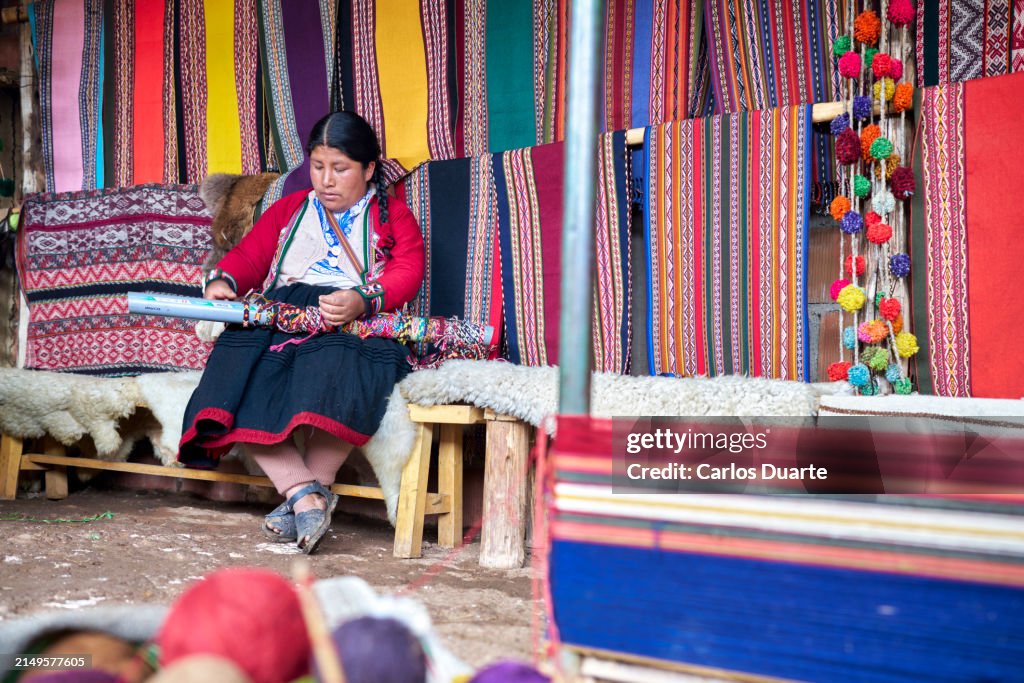 Tisserande indigène de la ville péruvienne de Chinchero sélectionnant des fils colorés à base de poils d’alpaga