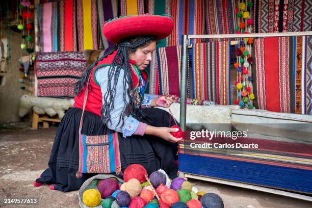 mujer indígena chinchero estirando los hilos que formarán la tela hecha con pelo de alpaca - moray cusco fotografías e imágenes de stock