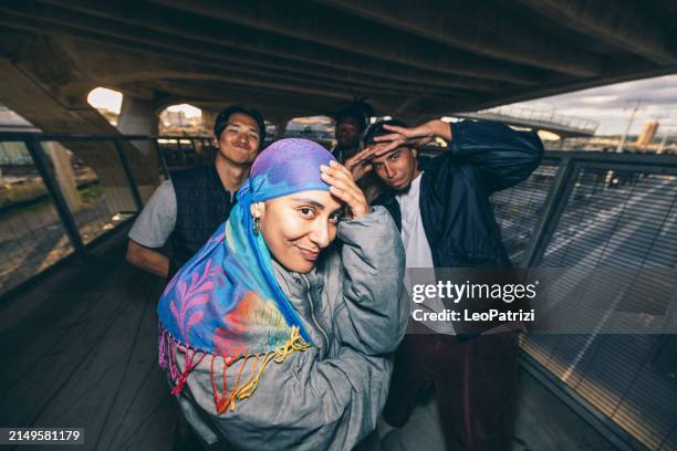 group of street hip hop breakdancers posing looking to camera - gangsta rappers stock pictures, royalty-free photos & images