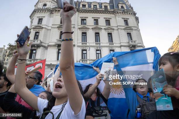 Group of demonstrators sing the Argentine National Anthem and raise their books during the rally. Protesters in favor of public and free education...