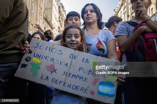 Two children and their mother hold a placard saying: "we are from the public university, we will always defend it" during the rally. Protesters in...