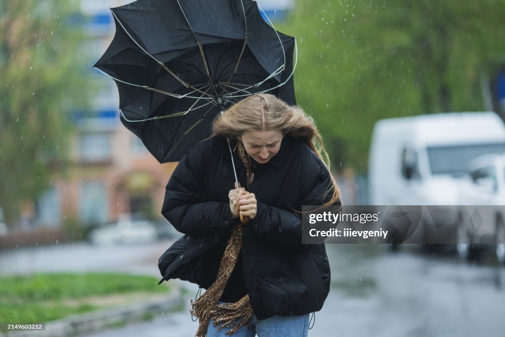 Mulher loira sob guarda-chuva. Tempo de tempestade. Chuva torrencial