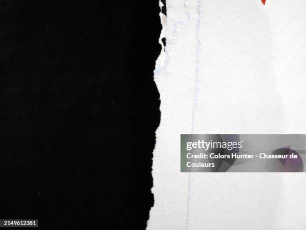 macro photography of a torn and textured white poster against a black background.
natural light and colors.
paris, france. - torn stock pictures, royalty-free photos & images
